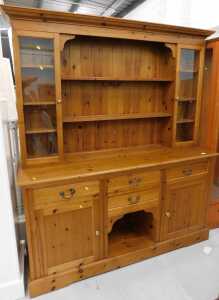 A pine kitchen dresser, with open shelves flanked by glazed shelves above four drawers, double...