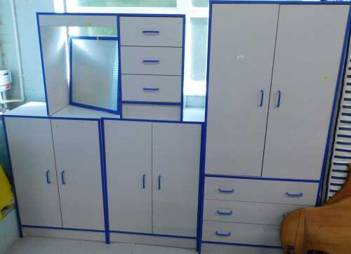 Various child's bedroom furnishings, desk, compactum wardrobe, cabinets, with blue trim.