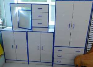 Various child's bedroom furnishings, desk, compactum wardrobe, cabinets, with blue trim.