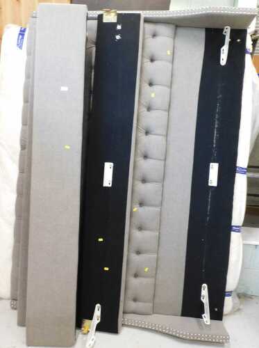 A 75" wide bed surround, sleigh type, in grey, with mattress in part covering.