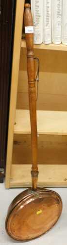 A copper warming pan, with a turned wooden handle.