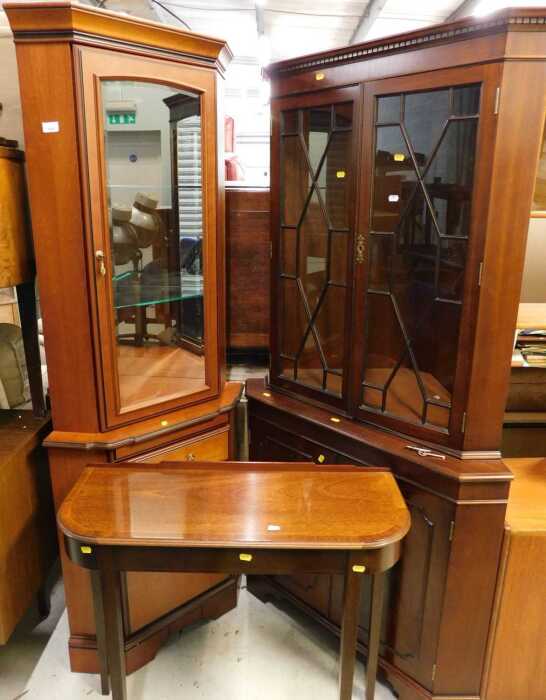 A mahogany finish demi-lune side table, and two freestanding corner cupboards.
