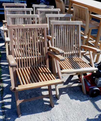 A set of eight slat back teak folding garden chairs.