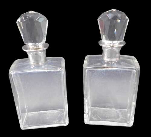 A pair of Elizabeth II cut glass and silver decanters, each of rectangular shouldered form, with...