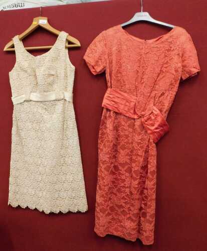 A lady's evening dress with raised with flowers in cream, together with a peach coloured evening...