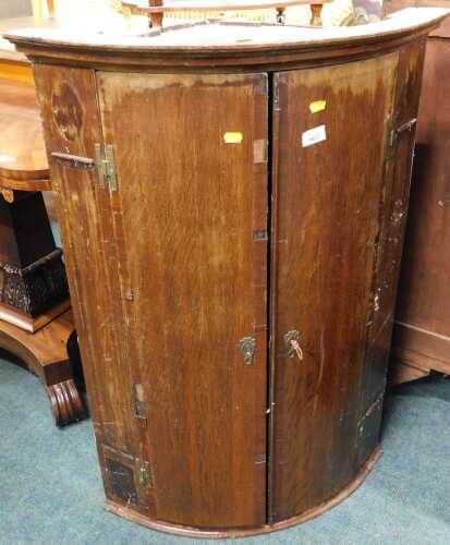 A 19thC oak barrel hanging corner cupboard. (AF)
