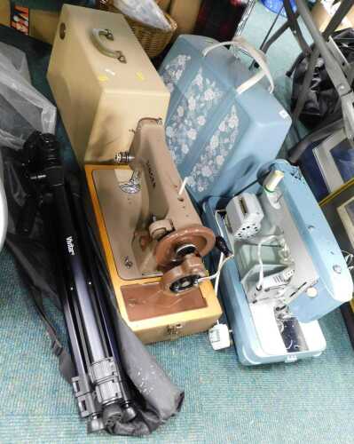 Two mid century cased sewing machines, together with a Vivitar camera tripod.