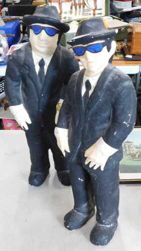A pair of painted papier mache figures, depicting Jake and Elwood Blues, The Blues Brothers.