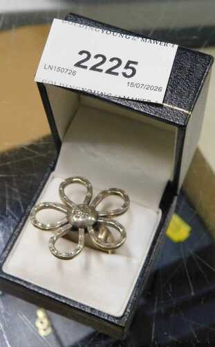 A flower dress ring, the elaborate five petal flower, 3cm wide, on a plain band stamped 925,...