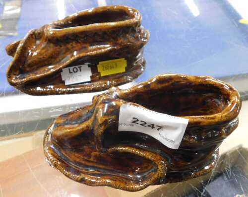 A pair of mid-20thC brown treacle glazed ceramic boots.