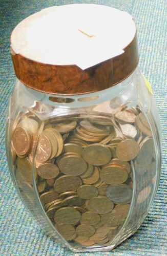 Coins, a glass jar containing modern British copper coinage.