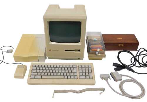 A Mackintosh Plus personal computer, with 9" monitor, with inset disc drive, keyboard, various...