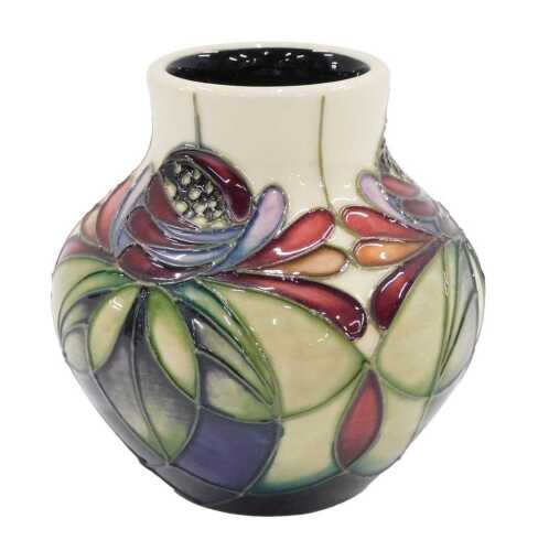 A Moorcroft pottery Anna Lily pattern vase, 10cm high, boxed.