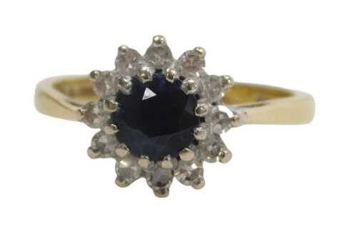 An 18ct gold sapphire and diamond cluster ring, the round brilliant cut sapphire surrounded by...