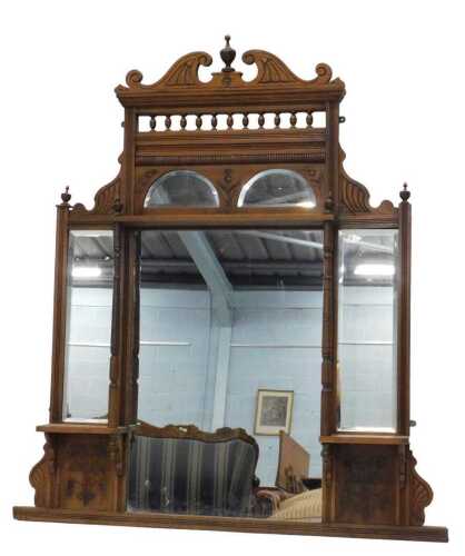 An Edwardian carved walnut overmantel mirror, with scroll top centred by urn, and three further...