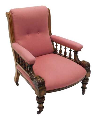 A Victorian showframe armchair, with overstuffed back, arms and seat, in later pink material, on...