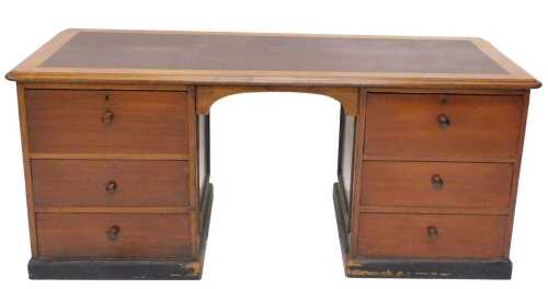 A 20thC mahogany twin pedestal writing desk, with one piece crimson leather top, raised above...