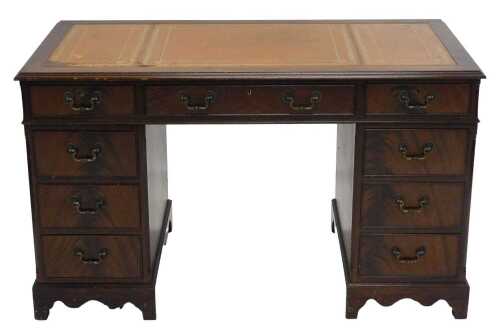 A late 20thC twin pedestal desk, with three part tooled leather top, raised above three frieze...