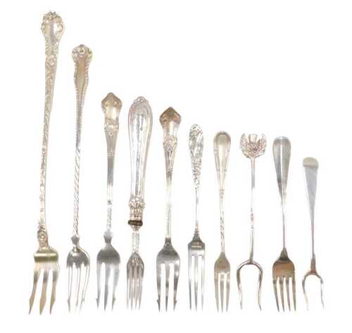 Ten various silver pickle and serving forks, to include a three pronged example with raised...