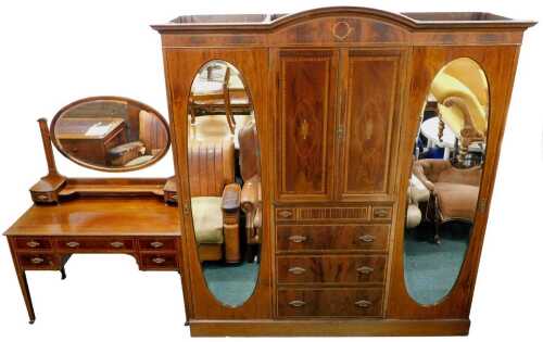 An Edwardian mahogany bedroom pair, comprising a boxwood strung and part inlaid triple wardrobe,...