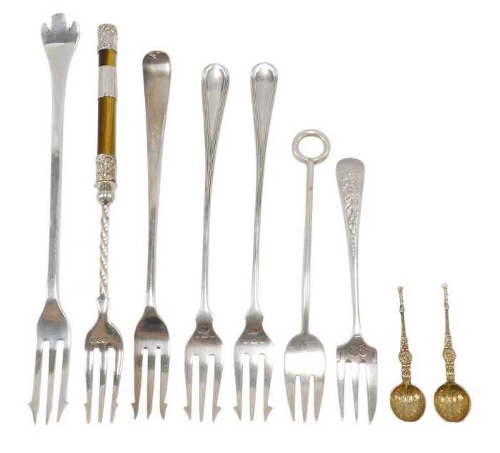 Nine various silver pickle forks and other serving items, two silver gilt miniature spoons,...