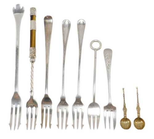 Nine various silver pickle forks and other serving items, two silver gilt miniature spoons,...