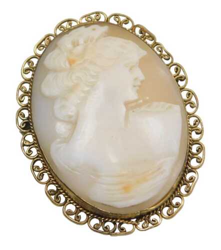 A 20thC shell cameo brooch, the oval cameo depicting maiden looking right, in a brushed gold...
