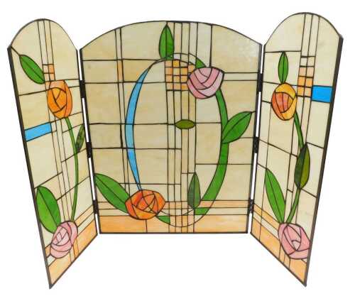 A three part Tiffany style design lead glass panel, with arched sides, profusely decorated with...