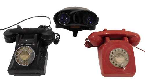 A vintage Bakelite telephone, in black with a cord attached receiver, with chrome fronted...