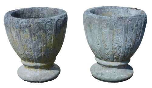 A pair of 20thC classical stone planters, each with urn tops, on inverted circular stems and...