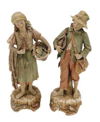 A pair of Royal Dux figures of boy and girl, he holding duck, she holding basket of fish, raised...