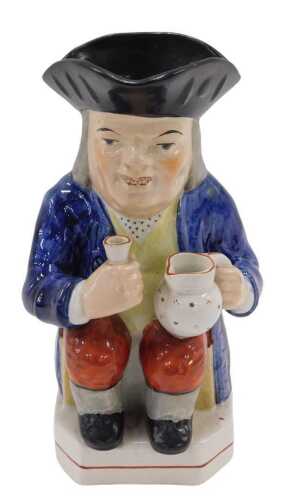 A late 19thC Yorkshire pottery Toby jug, the seated Toper holding jug and beaker, in blue jacket...