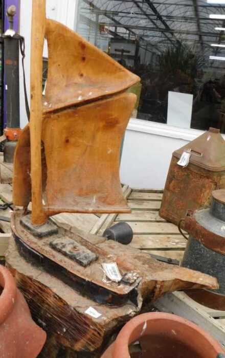 V - A 20thC rustic carved wooden boat, on a driftwood base, 111cm high. NB. VAT is payable on the...