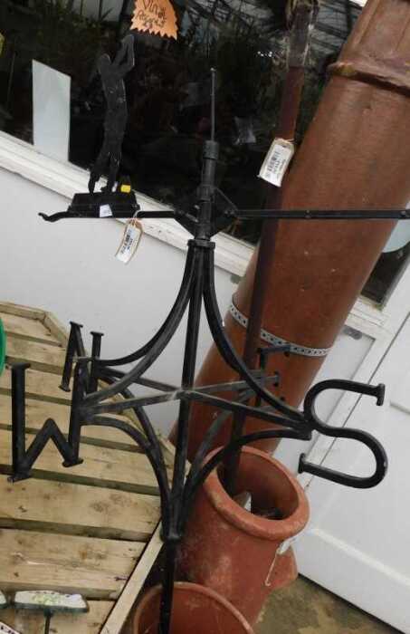V - A wrought iron weather vane, with articulated top, set with a golfer, in black, 158cm high. NB....