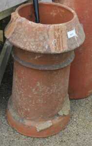 V - An early 20thC clay baked chimney pot planter, of inverted circular form, 58cm high. NB. VAT is...