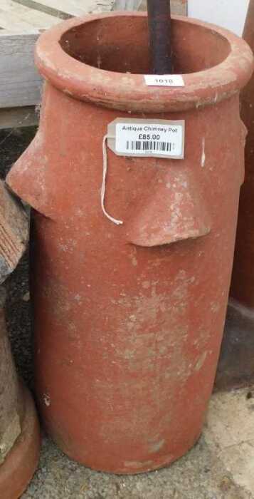 V - An early 20thC clay-baked chimney pot planter, with open sections to the cylindrical body, 67cm...
