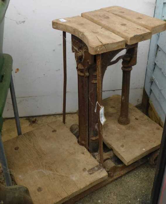 V - A 19thC wooden and cast iron scale, on a truckle base, with articulated slatted top and wooden...