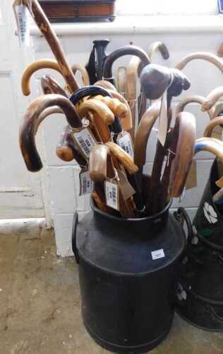 V - Various walking sticks, contained in an early 20thC milk churn, with fixed handles, 58cm high....