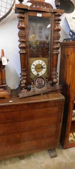 V - A Victorian walnut-cased Vienna wall clock, with heavily carved finial, raised above a 7cm wide...