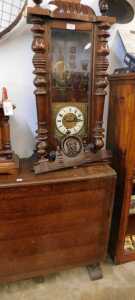 V - A Victorian walnut-cased Vienna wall clock, with heavily carved finial, raised above a 7cm wide...
