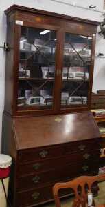 V - A Georgian mahogany bureau bookcase, the fixed cornice with two shell paterae, raised above a...