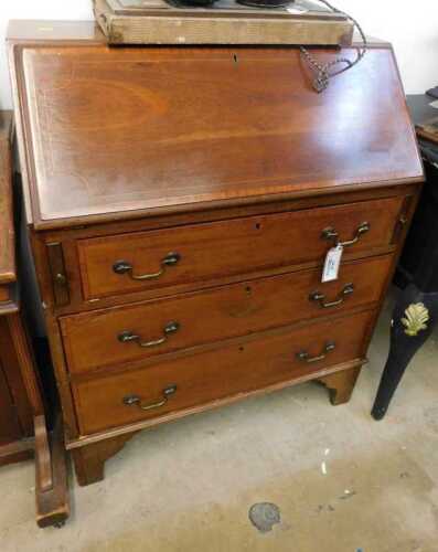 V - An Edwardian mahogany and boxwood-strung bureau of small proportion, the fall revealing a fitted...