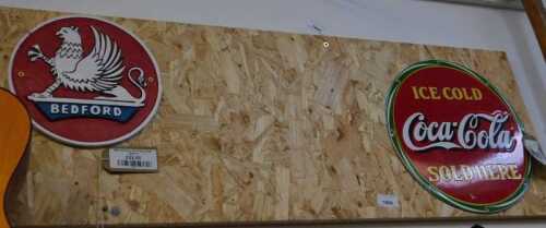 V - Two reproduction signs, for Bedford Lorries and Ice Cold Coca-Cola Sold Here, on a wooden...