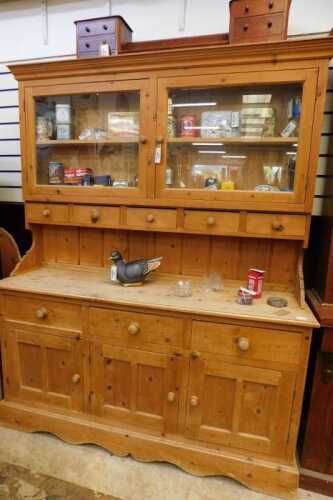 V - An early 20thC pine dresser, the upper section with fixed cornice, raised above two glazed doors...