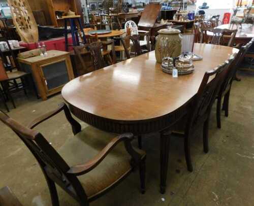 V - An early 20thC mahogany D-end dining table, with a heavily carved frieze, on circular reeded...