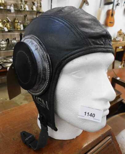 V - A US Navy aviator's leather flying helmet, 25cm high, together with a polystyrene model head. NB....