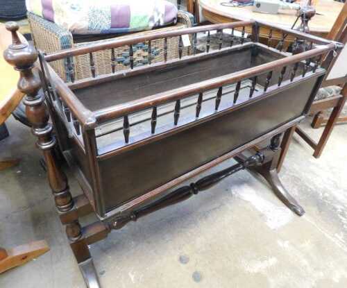 V - An early 20thC mahogany child's crib, of rectangular form, on turned stand terminating in scroll...