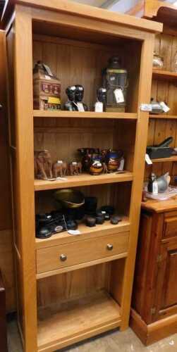 V - A 20thC lightwood bookcase, with three shelves above the drawer and a further shelf beneath, on...