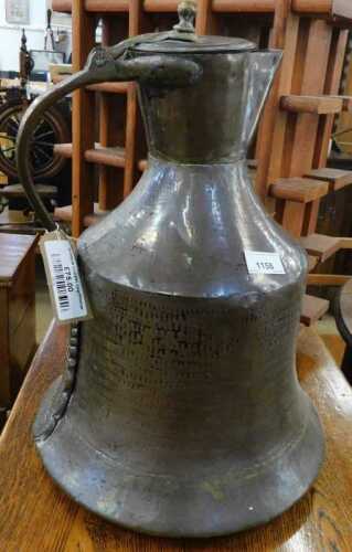 V - An early 20thC copper pitcher, with articulated lid and partially hammered bell-shaped body,...
