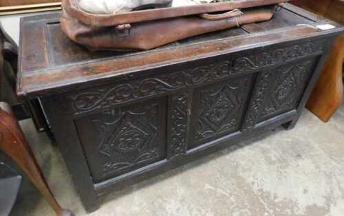 V - A 17thC oak coffer, of rectangular form, the plain three-panelled top raised above a heavily...